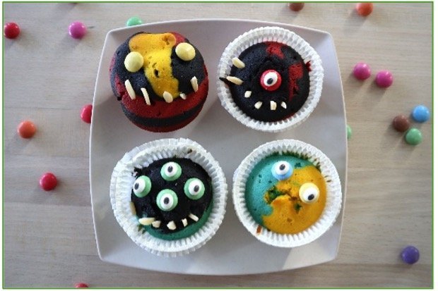 Bunte Monstermuffins auf einem weißen Teller