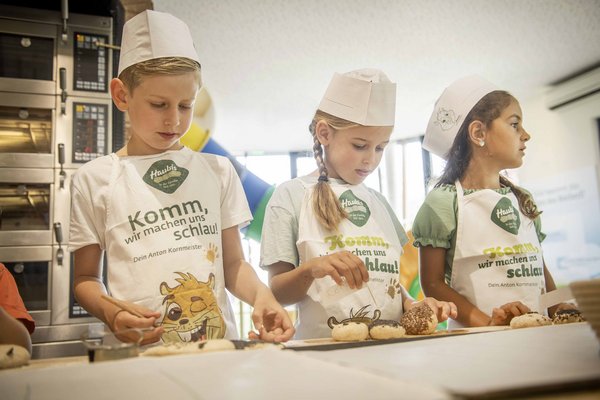 Kinder beim backen von Semmerl in der Kinderbackstube im Haubiversum