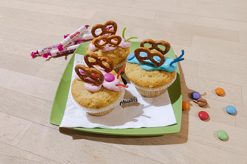bunte Schmetterlings Muffins auf einem grünen Teller